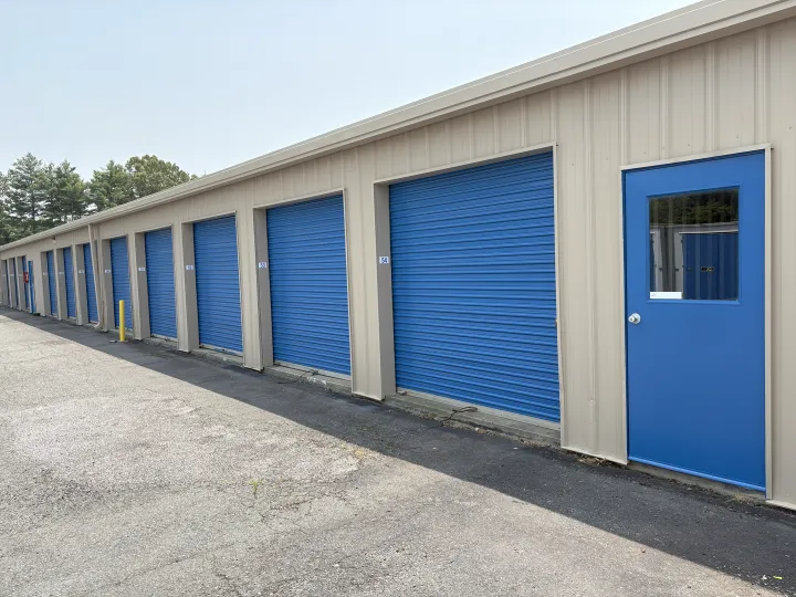Beige metal self-storage building with blue roll-up doors