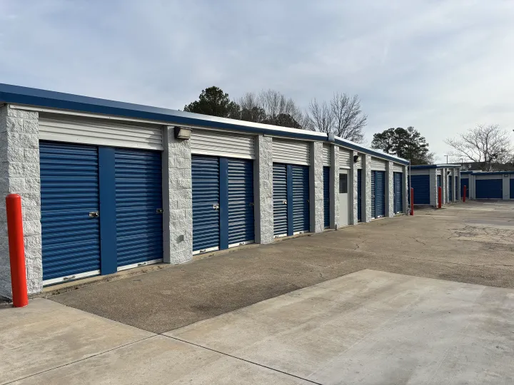 Concrete self-storage building with blue roll-up doors