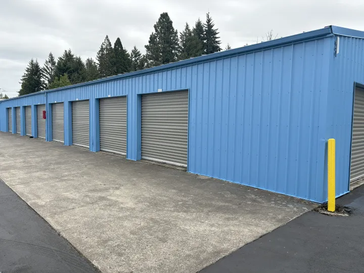Blue metal self-storage building with gray roll-up doors