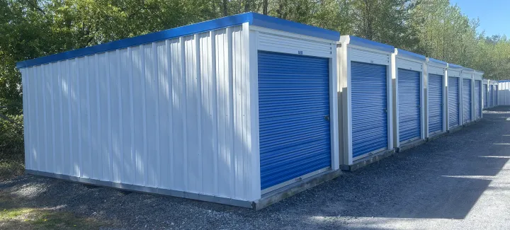 White metal self-storage buildings with blue trim and blue roll-up doors