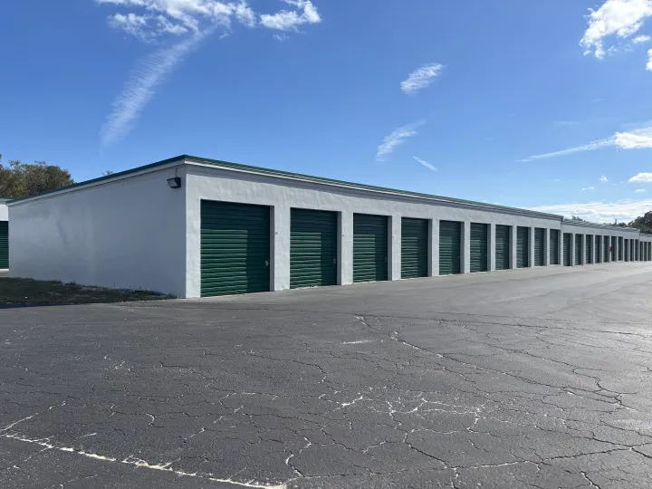 White self-storage building with green doors and trim