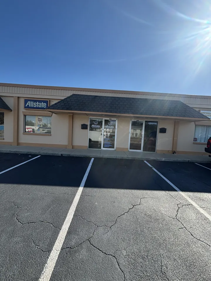 Beige office storefront with glass entrance doors and dark shingled awning