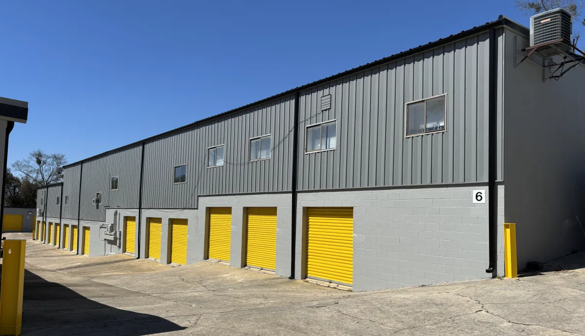 Large gray self-storage building with bright yellow roll-up doors